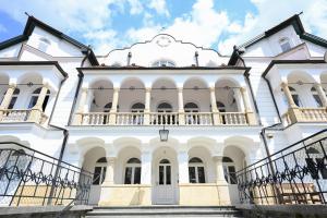 Großes weißes Gebäude mit Balkon in der Unterkunft Waldschlössl Schneedörfl in Reichenau