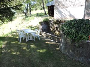 a table and chairs sitting in a yard at Gite au pied du mont Lozère 2 in Mas-dʼOrcières