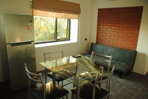 a dining room with a glass table and chairs at Departamentos Incahuasi in Bahia Inglesa +16 photos