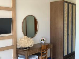 a room with a table and a mirror at Gia An Hung Guest House in Mui Ne