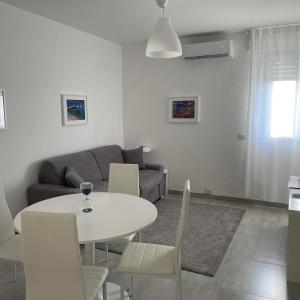 ein Wohnzimmer mit einem weißen Tisch und Stühlen in der Unterkunft Appartamento Suite Calipso in Pozzallo