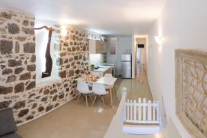 a kitchen with a white table and a stone wall at Sokaki House in Hydra