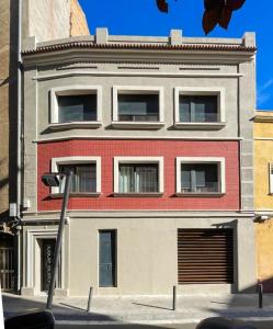 a red and white building on a city street at Barcelona Touch Apartments in Hospitalet de Llobregat