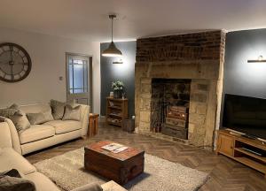 a living room with a couch and a fireplace at Rose Cottage in Morpeth