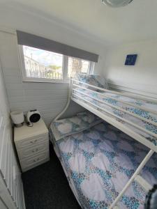 1 dormitorio con 2 literas y ventana en Chalet 66, en Skegness