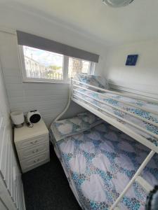 um quarto com 2 beliches e uma janela em Chalet 66 em Skegness