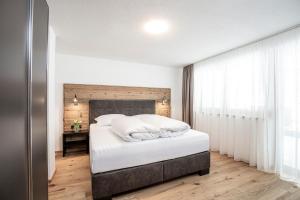 a bedroom with a large white bed with white pillows at APART GRIES in Längenfeld