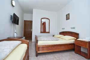a bedroom with two beds and a mirror at Hotel Grbalj in Budva