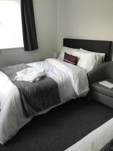 a bedroom with a bed with a pillow and a chair at Ladysmith House in Plymouth