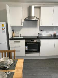a kitchen with white cabinets and a black oven at Ladysmith House in Plymouth