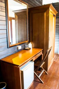 a kitchen with a wooden desk and a mirror at The Bank River House Ayutthaya in Ban Yai (1)