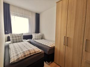 ホールマージールにあるSandbankのベッドルーム1室(ベッド2台、キャビネット、窓付)