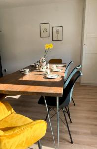 a dining room table with chairs and a vase with yellow flowers at Haus Mosel Tales in Cochem für bis zu 9 Personen in Cochem