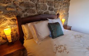 a bed with pillows and a lamp on it at Casa Grande de Cristosende in Cristosende