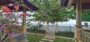 a garden with a view of the ocean at Solaluna Beach Homestay in Amed