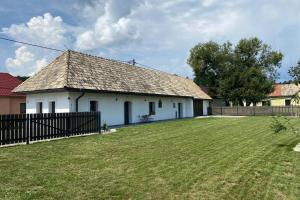 una casa blanca con una valla y un patio en Biely domček so záhradou v malej obci Devičie, en Devičie