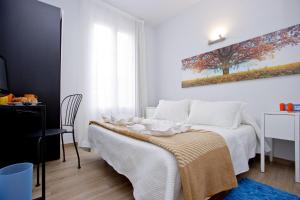 a bedroom with a bed with white sheets and a painting on the wall at Barcelona City Hotel in Barcelona