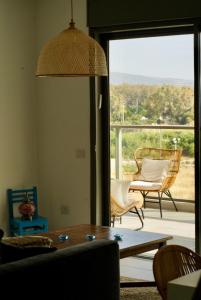 - un salon avec une table, des chaises et une grande fenêtre dans l'établissement 4 Bedroom Beach Apartment with Stunning Views, à Nahariya