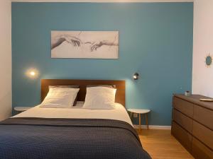 ein Schlafzimmer mit einem Bett und einer blauen Wand in der Unterkunft Le 44 - T2 rénové moderne et confortable en centre-ville in Montluçon