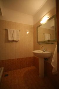 a bathroom with a sink and a mirror and towels at Akti Damnoni in Damnoni