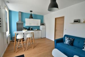 ein Wohnzimmer mit einem blauen Sofa und einem Tisch in der Unterkunft Le 44 - T2 rénové moderne et confortable en centre-ville in Montluçon