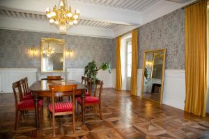a dining room with a table and chairs and a chandelier at Castel serein in Maubec