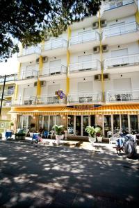 - un grand bâtiment avec des chaises devant dans l'établissement Hotel Medusa, à Sottomarina