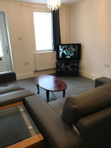 a living room with a couch and a table and a tv at Ladysmith House in Plymouth