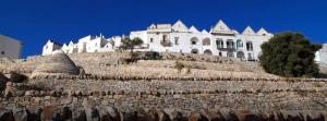 a large white house on top of a stone wall at Villa Stella Cadente in Serranova