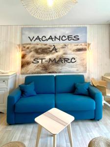um sofá azul numa sala de estar com uma placa em Appartement t2 , bord de mer, accès direct plage em Saint-Nazaire