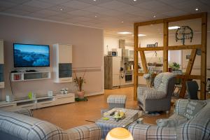 Una sala de estar con sofás y un televisor de pantalla plana. en am Erxleben-Hotel, en Quedlinburg
