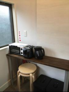 a counter with a toaster and a microwave on it at Iida Accommodation in Iida
