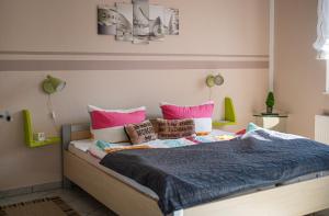 1 cama con almohadas y sábanas rosas y azules en am Erxleben-Hotel, en Quedlinburg