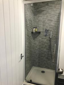 a bathroom with a shower with a bath tub at No1 The Smithy in Tattenhall