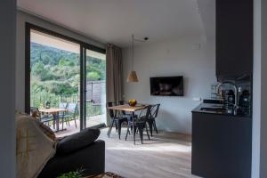 eine Küche und ein Wohnzimmer mit einem Tisch und Stühlen in der Unterkunft Apartaments Agulles de Montserrat in Monistrol de Montserrat