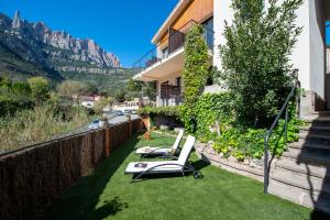 einen Balkon mit zwei Liegestühlen auf dem Rasen in der Unterkunft Apartaments Agulles de Montserrat in Monistrol de Montserrat