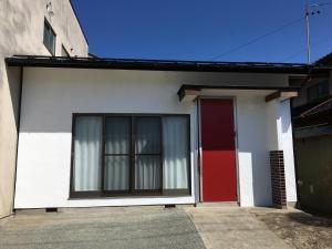 a white and red house with a red door at Iida Accommodation in Iida +2 photos