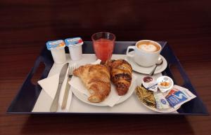 a tray of food with pastries and a cup of coffee at Hotel Trastevere in Rome