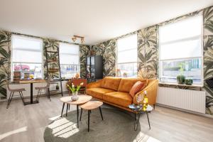 a living room with a couch and a table at Beach Break Deco & Sleeping in Katwijk aan Zee