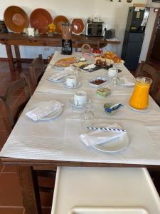 a table with plates and napkins on top of it at Monte das Palmeiras in Monte do Simão Vaz