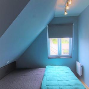 a blue bedroom with a bed and a window at Duplex met zwembad Neoportus in Nieuwpoort +3 photos