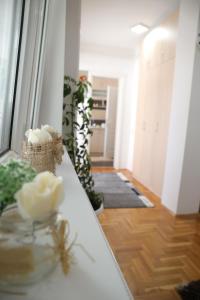 a room with a table with white flowers on it at Apartman Rastko in Nova Varoš