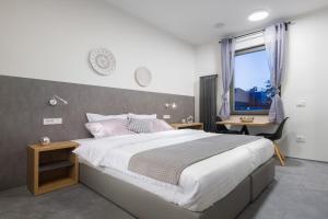 Un dormitorio con una cama grande y un escritorio y una ventana. en Vila Emona - Central Apartments - Free Parking, en Liubliana