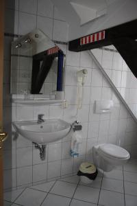 a bathroom with a sink and a toilet at Hotel & Restaurant Aragwi in Salzwedel