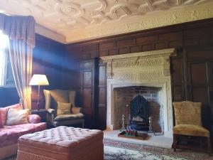 a living room with a fireplace and a chair at Old Church Farm in Rudgeway