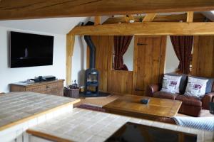 a living room with a couch and a wood stove at Finchden Barn in Tenterden