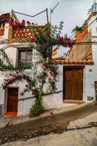 een wit gebouw met bloemen aan de zijkant bij Casa Fuensanta balcón al mar de la Alpujarra in Granada