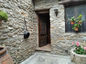 ein Steinhaus mit einer Tür und Topfpflanzen in der Unterkunft Casa Fuensanta balcón al mar de la Alpujarra in Granada