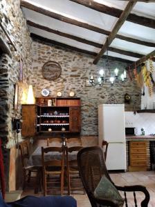 格拉納達的住宿－Casa Fuensanta balcón al mar de la Alpujarra，厨房配有桌椅和冰箱。