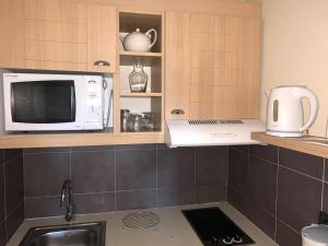 una cucina con forno a microonde e lavandino di Appartement dans résidence de standing avec terrasse et vue mer a Le Pouliguen Altre 4 foto